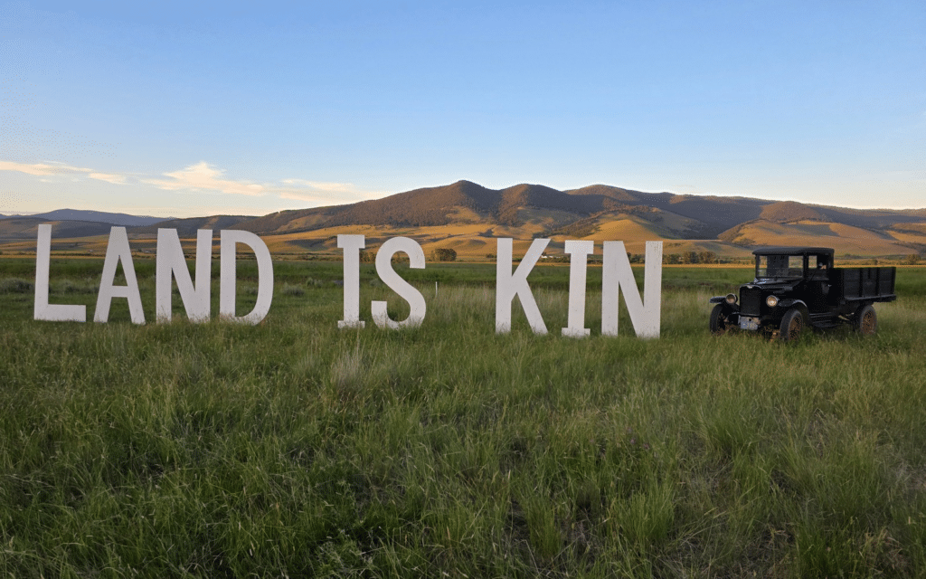 Episode 81 of The Wild Idea Podcast: An Image of word art "Land is Kin" from the 2026 Old Salt Festival
